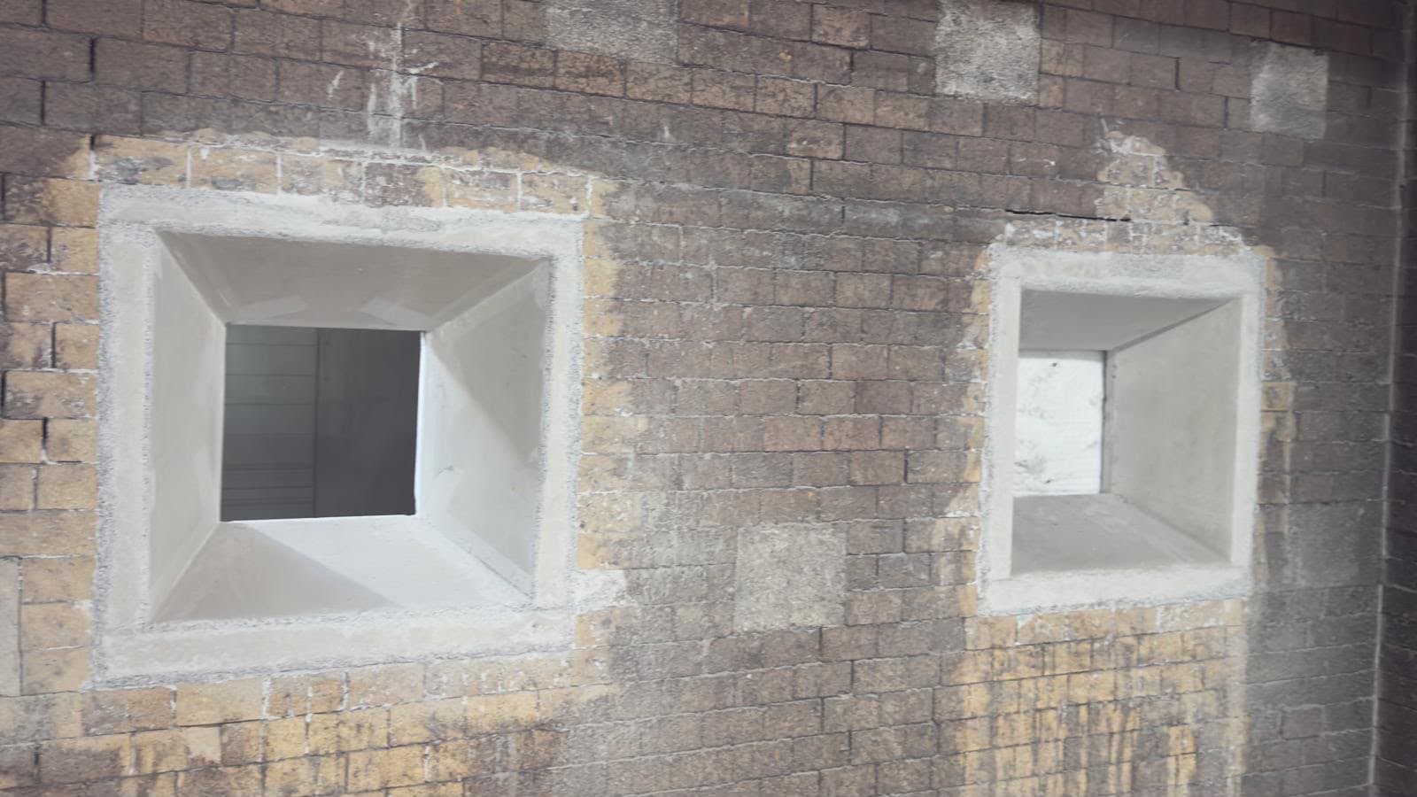 Zwei neu gegossene Schaufenster in der Wand eines Brandversuchsofens, eingesetzt in das alte Mauerwerk